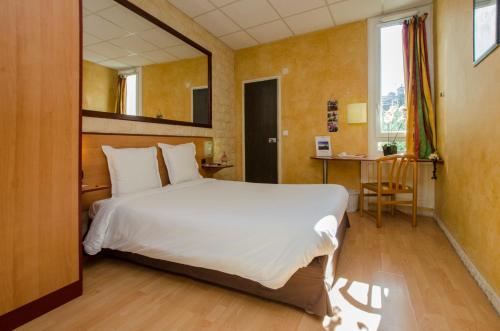 Un pat sau paturi într-o cameră la Hôtel Bosquet Pau Centre