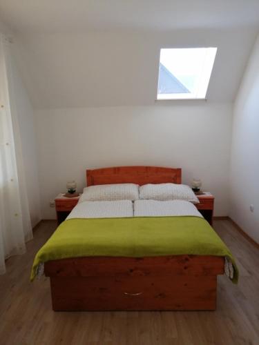 a bedroom with a bed with a green blanket on it at R&G APARTMENT in Žirovnica