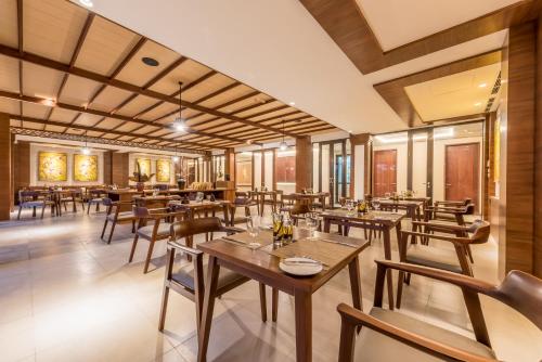 a restaurant with wooden tables and chairs at tanadewa Resort Ubud Bali by Cross Collection in Ubud