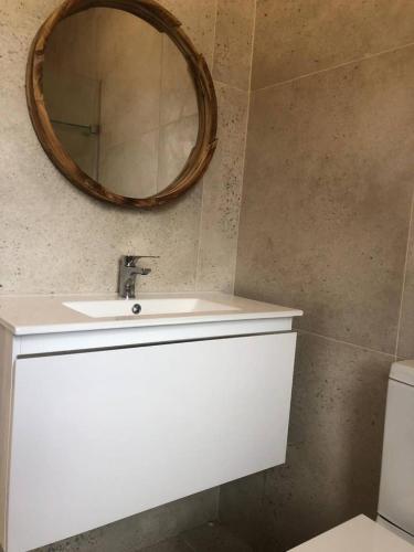 a bathroom with a sink and a mirror on the wall at Still Bay East Beach Apartment in Stilbaai