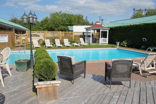 a pool with chairs and a table and a light pole at Willow Bend Motel in Truro