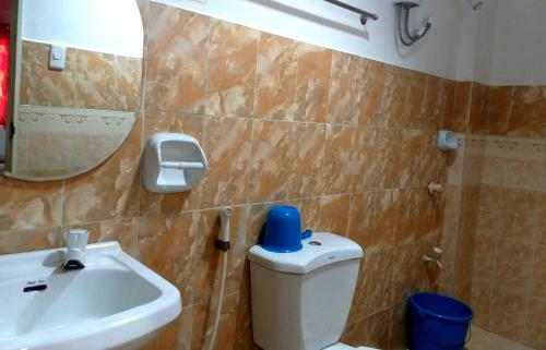 bagno con servizi igienici, lavandino e specchio di Park Vil-la Apartelle a Manila