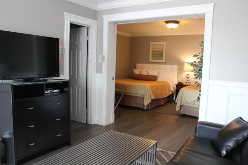 a living room with a television and a bed at Willow Bend Motel in Truro