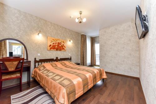 a bedroom with a bed and a table and a desk at Apartamentai Pluke in Palanga