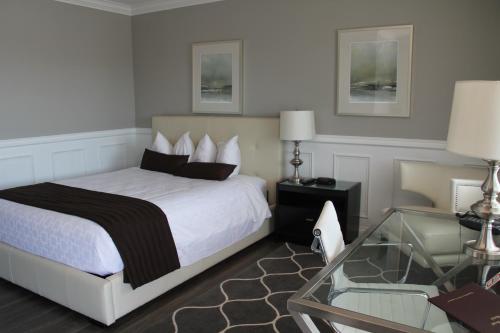 a bedroom with a bed and a glass table at Willow Bend Motel in Truro