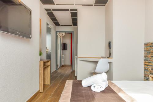 ein Hotelzimmer mit einem Bett und einem Flachbild-TV in der Unterkunft Mar I Sol Logis in Saint-Cyprien