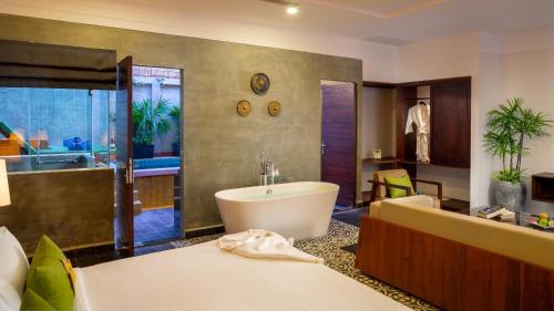 a bathroom with a bath tub and a sink at Sabara Angkor Resort & Spa in Siem Reap