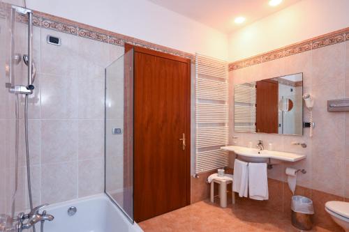 a bathroom with a shower and a sink and a tub at Hotel Master in Brescia