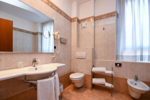 a bathroom with a sink and a toilet and a mirror at Hotel Master in Brescia