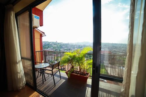 a room with a balcony with a table and a view at Bukoto Heights Apartments in Kampala