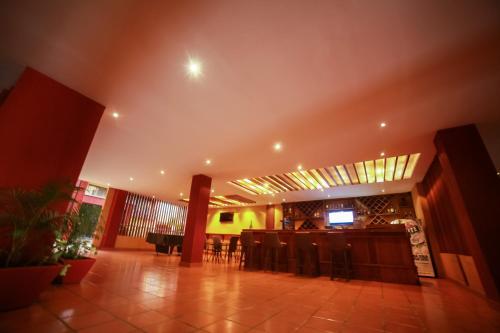 a room with a table and chairs and a piano at Bukoto Heights Apartments in Kampala