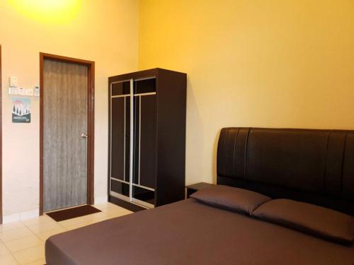 a bedroom with a bed and a black cabinet at LindaNazri Homestay MITC Melaka in Melaka