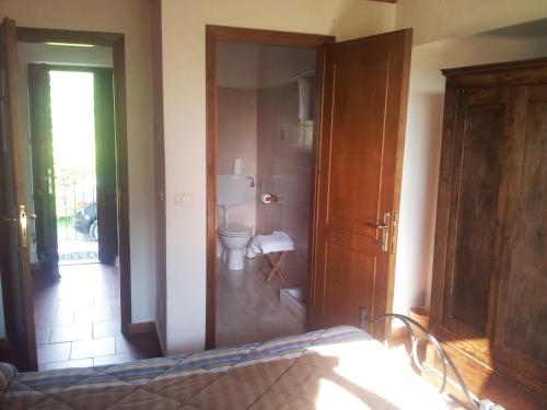 a bathroom with a toilet and a bed in a room at Agriturismo Il Picchio Verde in Licciana Nardi
