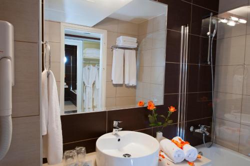 uma casa de banho com um lavatório e um chuveiro em Grand Hotel Holiday Resort em Hersonissos