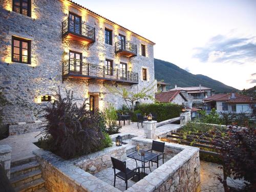 a building with chairs and a table in front of it at Villa Vager in Levidhion