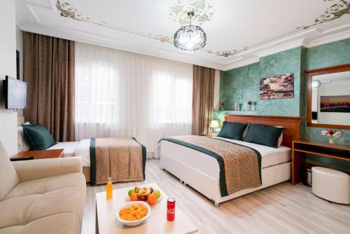Habitación de hotel con 2 camas y sofá en ATAM HOTEL, en Estambul