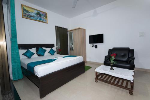 a bedroom with a bed and a chair and a tv at Aristo Hospitality Services Apartment, 1402,14th Floor in Mumbai