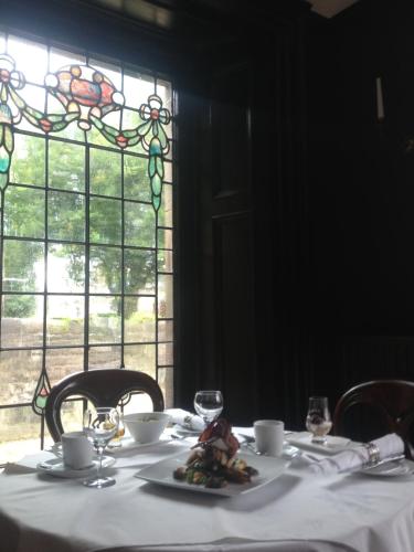 a table with a white table cloth and a stained glass window at 23 Mayfield in Edinburgh