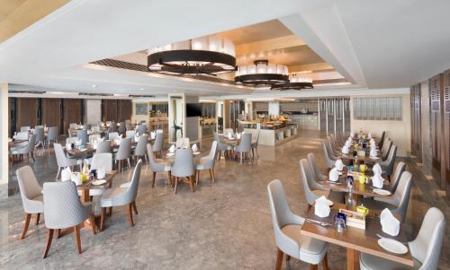 a dining room with tables and chairs and a restaurant at Radisson Blu Gorakhpur in Gorakhpur