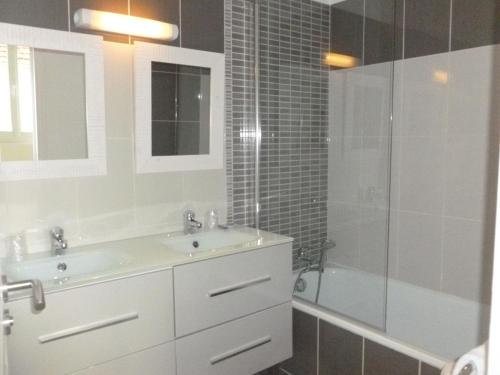 a bathroom with a sink and a shower and a tub at Hotel Jersey in Barneville-Carteret