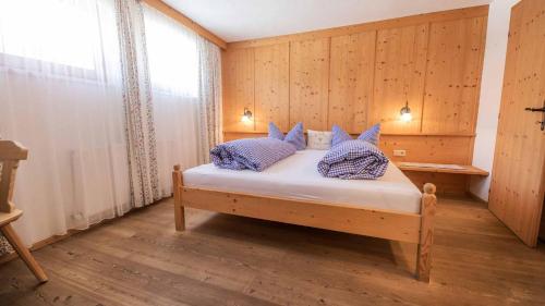a bedroom with a bed with blue and white pillows at Ferienhaus Sternhof in Mieders