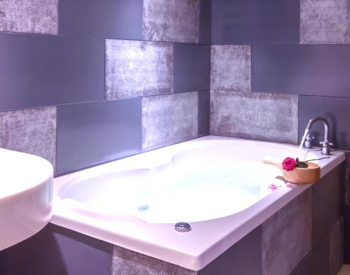 La salle de bains est pourvue d'une baignoire blanche et d'un lavabo. dans l'établissement Fukun No. 3 Motel, à Yilan