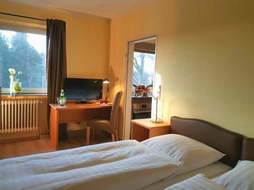 1 dormitorio con 1 cama y escritorio con ordenador en Apartments by Gasthof Bucksande en Apen