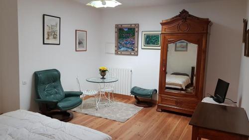 a bedroom with a bed and a table and a mirror at Alain et Nicole in Cognac