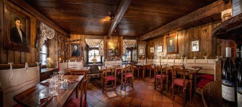 a dining room with wooden walls and tables and chairs at Bellevue Hotel & SPA in Cogne