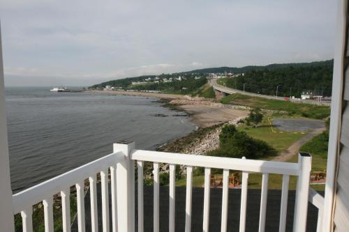a view of the ocean from a white fence at Motel et Chalets Bo-Fleuve Evangeline in Saint-Siméon