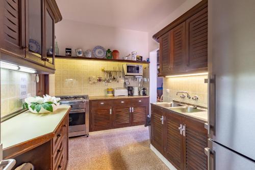 a large kitchen with wooden cabinets and a sink at Can Bernadet in San Jose