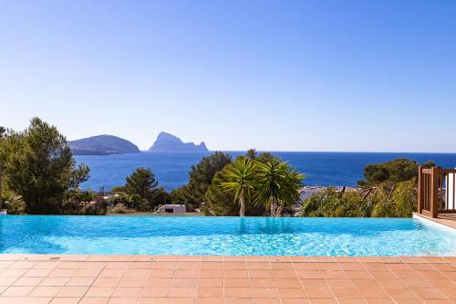 a swimming pool with a view of the ocean at Can Bernadet in San Jose