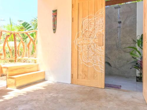 a wooden door with a design on the side of a house at Mandala Tribe Treehouses in Siquijor