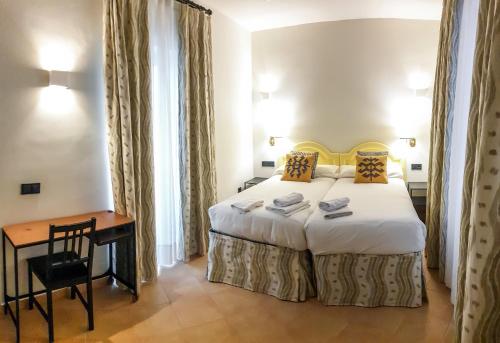 sypialnia z łóżkiem, biurkiem i stołem w obiekcie Turistic Apartment Sevillanos SL w Sewilli