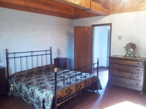 a bedroom with a bed and a dresser in a room at Agriturismo Il Picchio Verde in Licciana Nardi