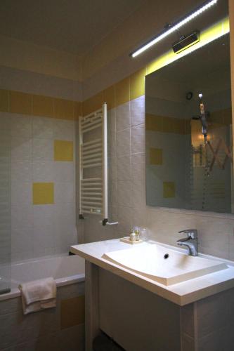 a bathroom with a sink and a tub and a mirror at Best Western Blanche de Castille Dourdan in Dourdan