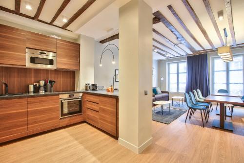 une cuisine avec des placards en bois et une salle à manger dans l'établissement 73 - Etienne Marcel, à Paris