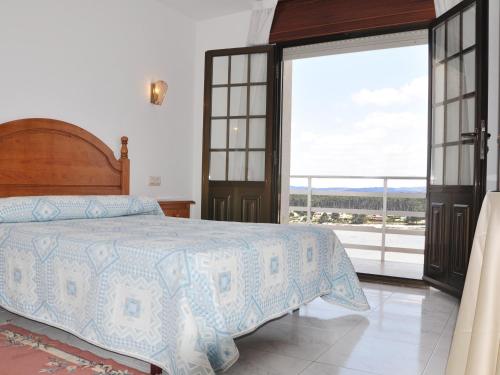a bedroom with a bed and a large window at Hostal Mourelos in O Grove