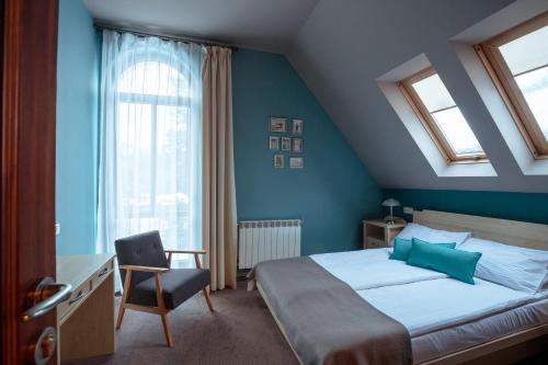 a bedroom with a bed and a desk and a chair at Villa Elise Park Pension in Stronie Śląskie