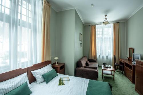 a hotel room with a bed and a couch at Villa Elise Park Pension in Stronie Śląskie