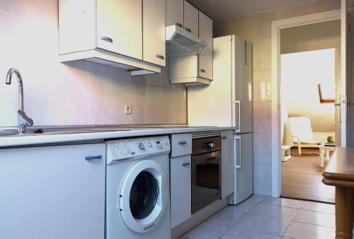 eine Küche mit einer Waschmaschine und einem Waschbecken in der Unterkunft Apartamento en Centro Historico de San Lorenzo de El Escorial in San Lorenzo de El Escorial