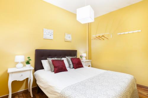 1 dormitorio con 1 cama blanca grande con almohadas rojas en Click&Flat Fira Gran Via, en Hospitalet de Llobregat