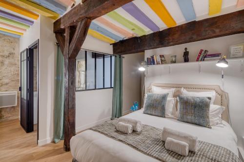 - une chambre avec un grand lit et un plafond coloré dans l'établissement Gravilliers, à Paris