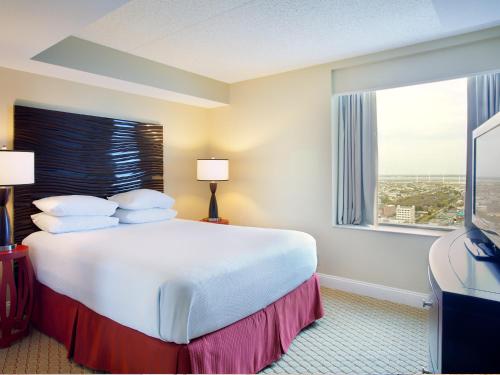 a hotel room with a large bed and a window at Boardwalk Resorts at Atlantic Palace in Atlantic City