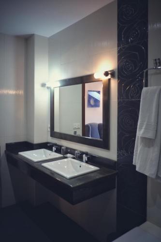 a bathroom with two sinks and a large mirror at La Juderia de Las Arribes in Vilvestre
