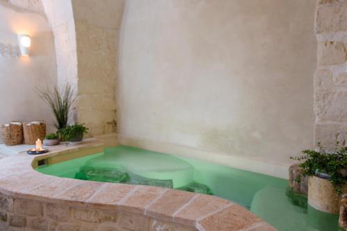 a hot tub in a room with green water at Akotika boutique in ‘Akko