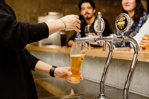 a bartender preparing a beer at a bar at WPÜ HOTEL HAKONE in Hakone