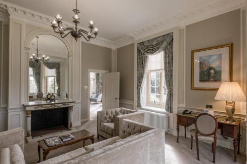 a living room with two couches and a fireplace at Tylney Hall Hotel in Hook
