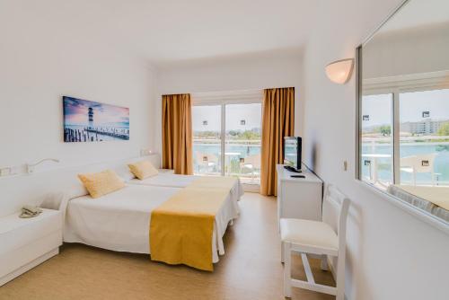 a hotel room with a bed and a television at Bellevue Lagomonte in Port d'Alcudia