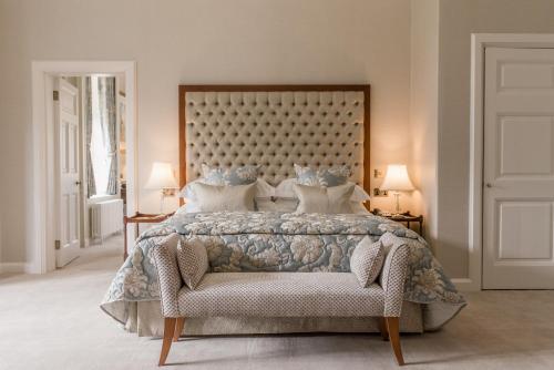 a bedroom with a large bed and a chair at Tylney Hall Hotel in Hook